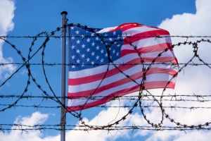 American flag behind barbed wire